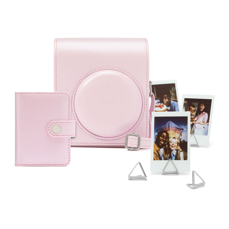 Cámara instantánea Fujifilm Instax en estuche rosa, incluye fotos impresas y soportes para fotografías.