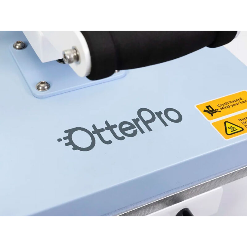 app720031-7-223 OtterPro máquina de prensado con diseño azul y warnings de seguridad para uso en sublimación de productos.