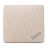 Tapa de cámara Instax, color rosa claro, superficie texturizada con logo en relieve, ideal para protección y estilo.