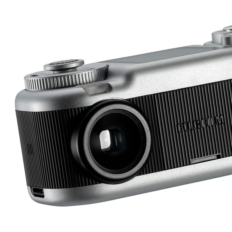fuj170518-1-65a Cámara Fujifilm con diseño retro, lente visible y detalles de textura negra y plateada para fotografía profesional.