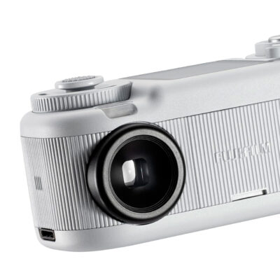 Cámara Fujifilm Instax Mini 11, Diseño Compacto En Color Plateado Con Lente Circular Y Detalles Texturizados.