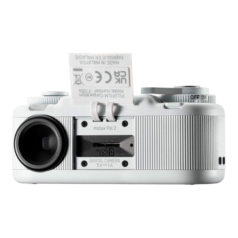 fuj170519-6-172 Cámara Fujifilm Instax Pal 2, vista posterior con lente y compartimento para tarjeta micro SD. Cámara instantánea compacta.