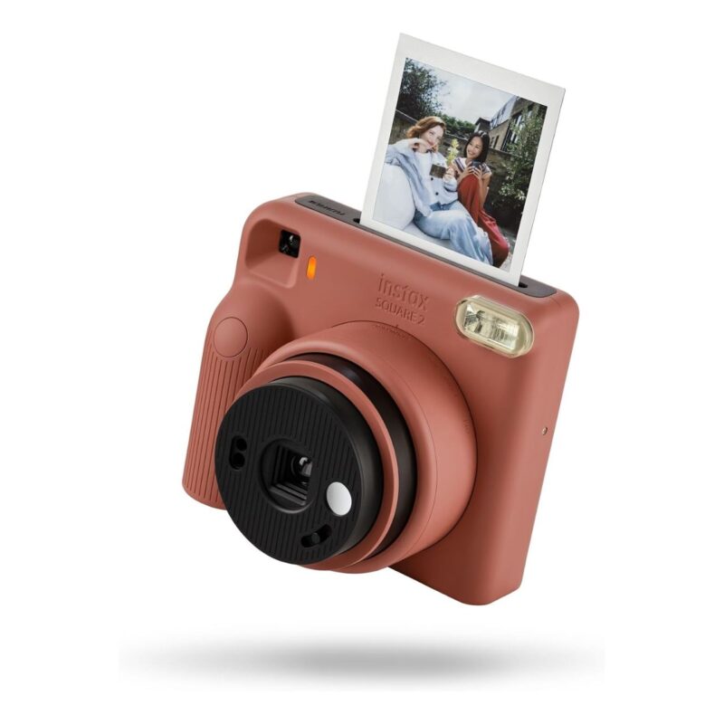 Cámara instantánea Fujifilm Instax Square 2, color rosa, con impresión de foto cuadrada visible.