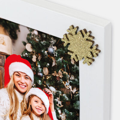Marco decorativo blanco con una foto navideña de madre e hija, adornado con copo de nieve dorado.